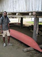 Justin Willy stands by a canoe being stored.